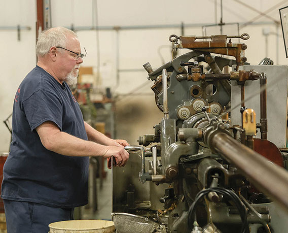 Decades-of-Innovation-568x459 man working at a machine